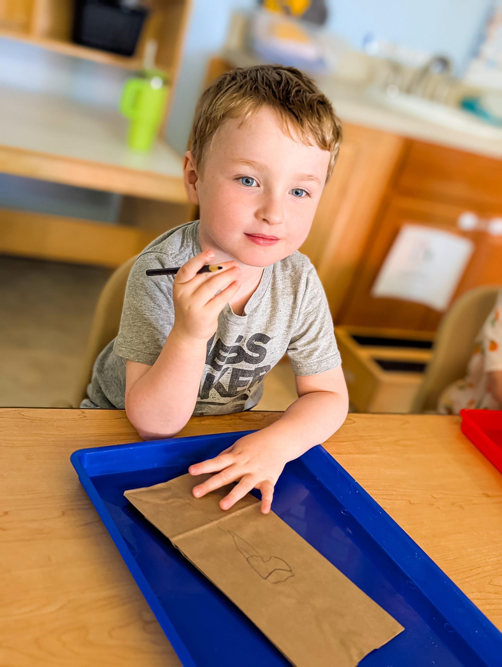 An Erie preschooler planning what to write for a Head Start classroom project.